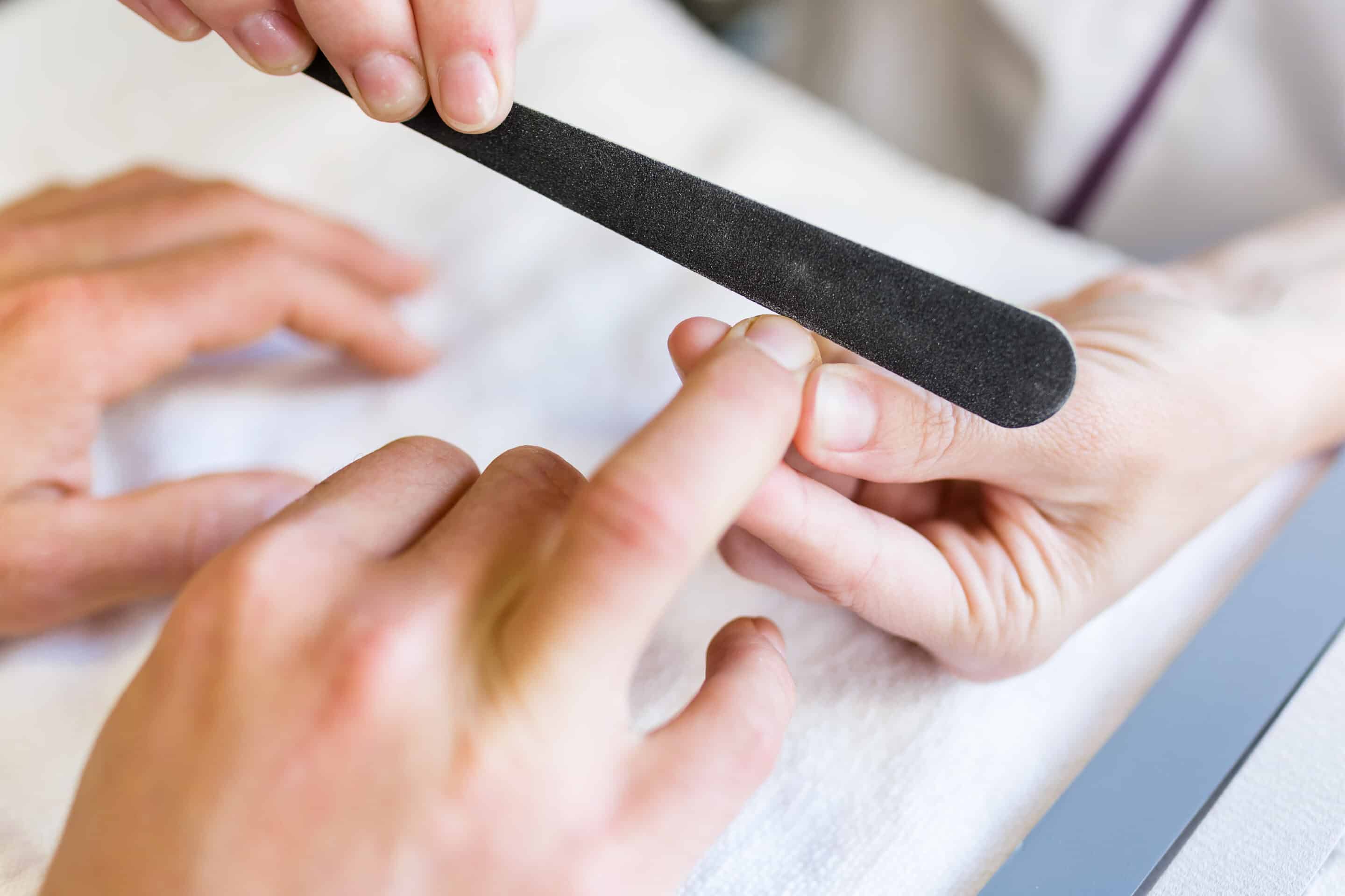 Young man doing manicure in salon. Beauty concept.